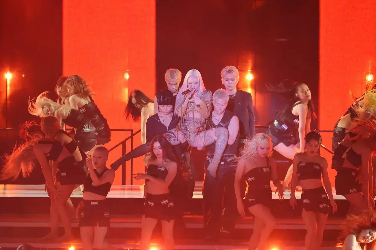 ▲日本饒舌歌手恰米娜（Chanmina，中）日前登上《紅白歌合戰》，不過她因為肉色緊身衣被批評穿著裸露低俗，粉絲出面緩頰：「見到黑影就開槍。」（圖／翻攝自X）