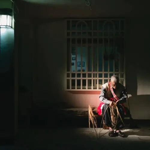 ▲黃美花父親喜歡坐在庭院編織竹藤手工藝品，父親在馬太鞍溪溢流後過世，照片成為追憶。（圖／黃美花提供）