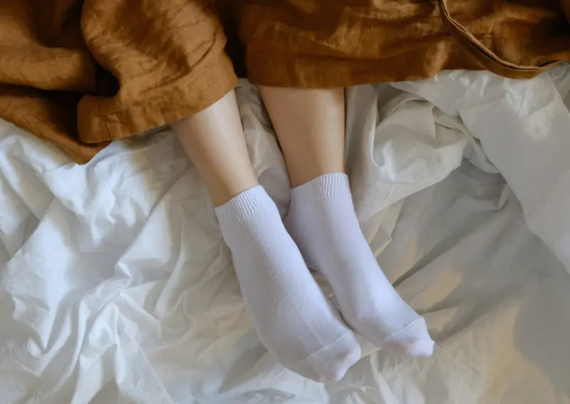 ▲許多人天冷時會穿襪子睡覺，但過去有民眾被阿嬤開罵「要死的人才會這樣穿」。對此，彰化馬光中醫診所劉宗昇醫師表示，有2類人建議別試，若壓迫恐讓血管狀況惡化，有如慢性自殺。（圖／取自unsplash）