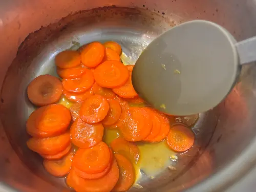 ▲蜜漬紅蘿蔔要煮到紅蘿蔔變軟、橙汁收乾變濃稠。（圖／記者徐銘穗攝）