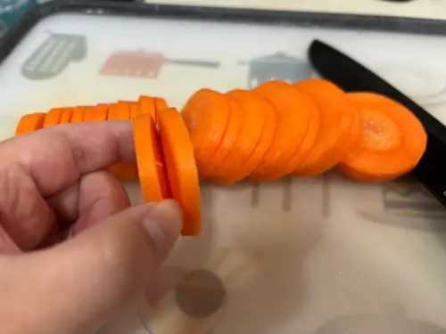 ▲紅蘿蔔第一刀切到底但不切斷，第二刀再切斷，形成一個「開口笑」口袋。（圖／記者徐銘穗攝）