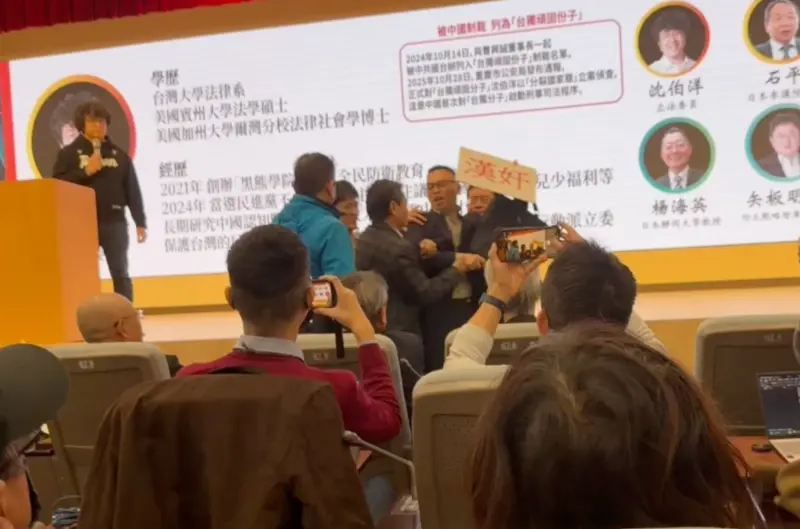 ▲印太戰略智庫今（9）日舉辦研討會，新黨副秘書長游智彬舉著「漢奸」的牌子進來鬧場，引發現場一陣騷亂。（圖／記者陳政嘉攝）