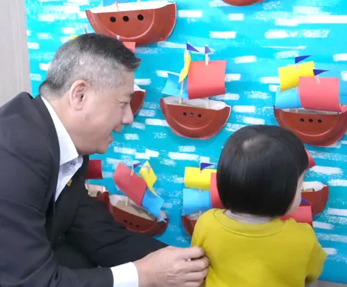 ▲台灣港務公司總經理王錦榮(左)攜手小朋友張貼傳承小帆船，場面溫馨，傳遞城市記憶與港口文化。(圖／高雄港務分公司提供)