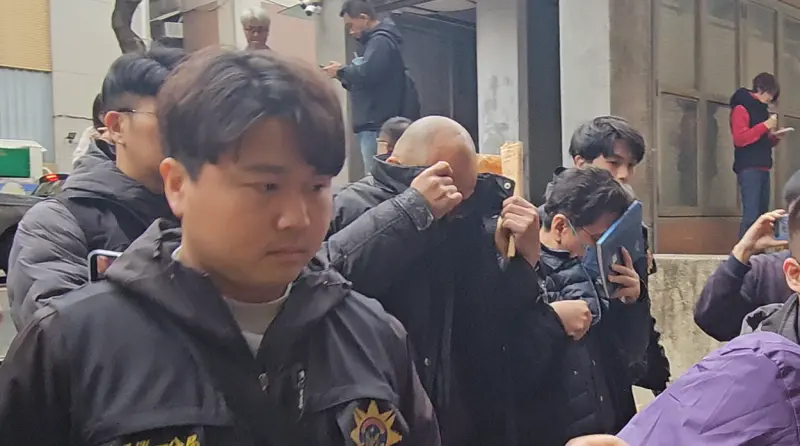    ▲警方移送涉嫌與滿堂紅麻辣鍋合作洗錢的金華苑詹姓負責人詹軒文（遮臉光頭男）、旺紅公司莊姓負責人（筆記本遮臉男）到台北地檢署。（圖／記者劉松霖攝）  