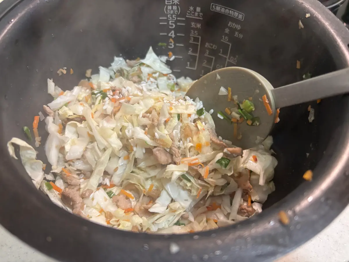 將炒好的配料倒入內鍋，與洗淨的 2 杯米混合，加入 2 杯水及調味料。