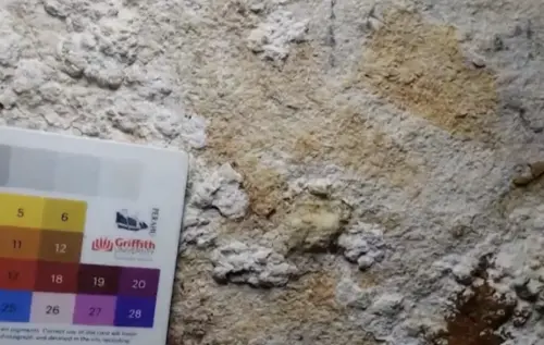 ▲透過分析覆蓋在壁畫表面的礦物沉積層，科學家成功測定這批手印的最低年代為6萬7,800年前，使其成為目前世界上已知最古老的洞穴藝術。（圖／翻攝自影片）