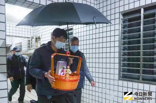 ▲ 家屬在法師引導下返回火警現場進行招魂儀式，由弟弟詹庭豪捧著詹能傑靈位，在叔叔撐傘陪同下離開社區，父母隨行在後，神情哀戚。（圖／攝影嚴俊強）