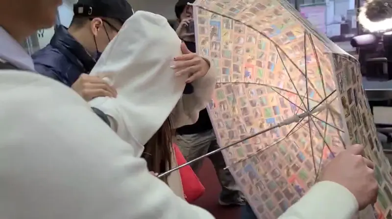 ▲蕭漢森的女兒蕭又綺交保離開地檢署時,使用雨傘開路對堵訪的媒體突圍。(圖/翻攝畫面)