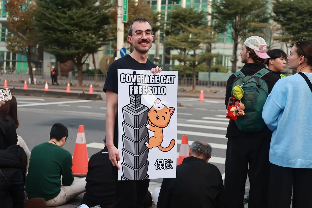 ▲霍諾德要來了，許多粉絲一早齊聚台北101幫打氣，還有外國人拿著一張寫著「保險」的海報，希望霍諾德平安完成挑戰。（圖／記者葉政勳攝）