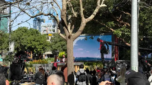 ▲信義廣場有Netflix大螢幕轉播，民眾轉頭可見台北101大樓，兩邊畫面都看到。（圖／記者蕭涵云攝）