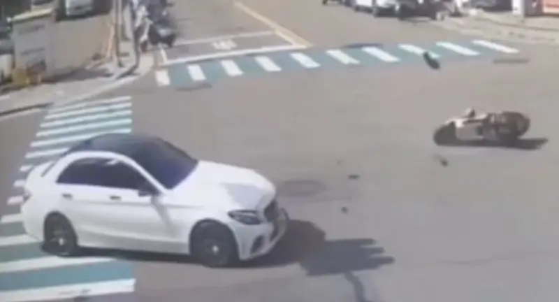 ▲23日台中烏日路口停等紅燈的機車遭賓士追撞，夫妻倒地滑行逾10公尺。丈夫腦出血住ICU、妻子骨折腦震盪。（圖／翻攝畫面）