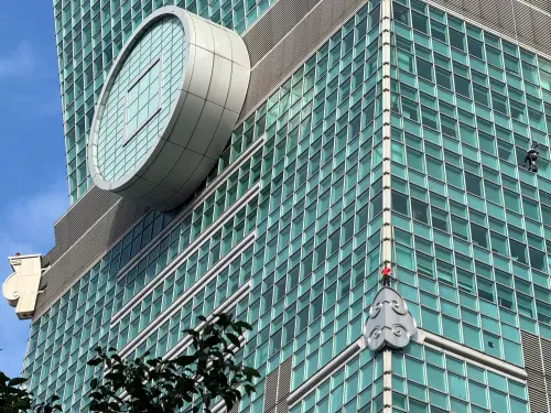 ▲霍諾德挑戰徒手攀爬台北101大樓，站上第一個祥雲設計，還回頭向民眾致意。（圖／記者蕭涵云攝）