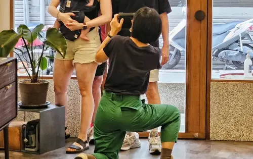 ▲網友翻出店家在2023年貼出一張溫馨合照，畫面中疑似一名女子揹著外國嬰兒，店家甚至單膝下跪幫忙拍照，質疑店家雙標。（圖／當事店家IG）