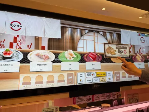 ▲壽司郎微風南山店引進「螢幕迴轉壽司」，觸控巨型螢幕瀏覽餐點與點餐，還有遊戲可以玩。（圖／記者蕭涵云攝）