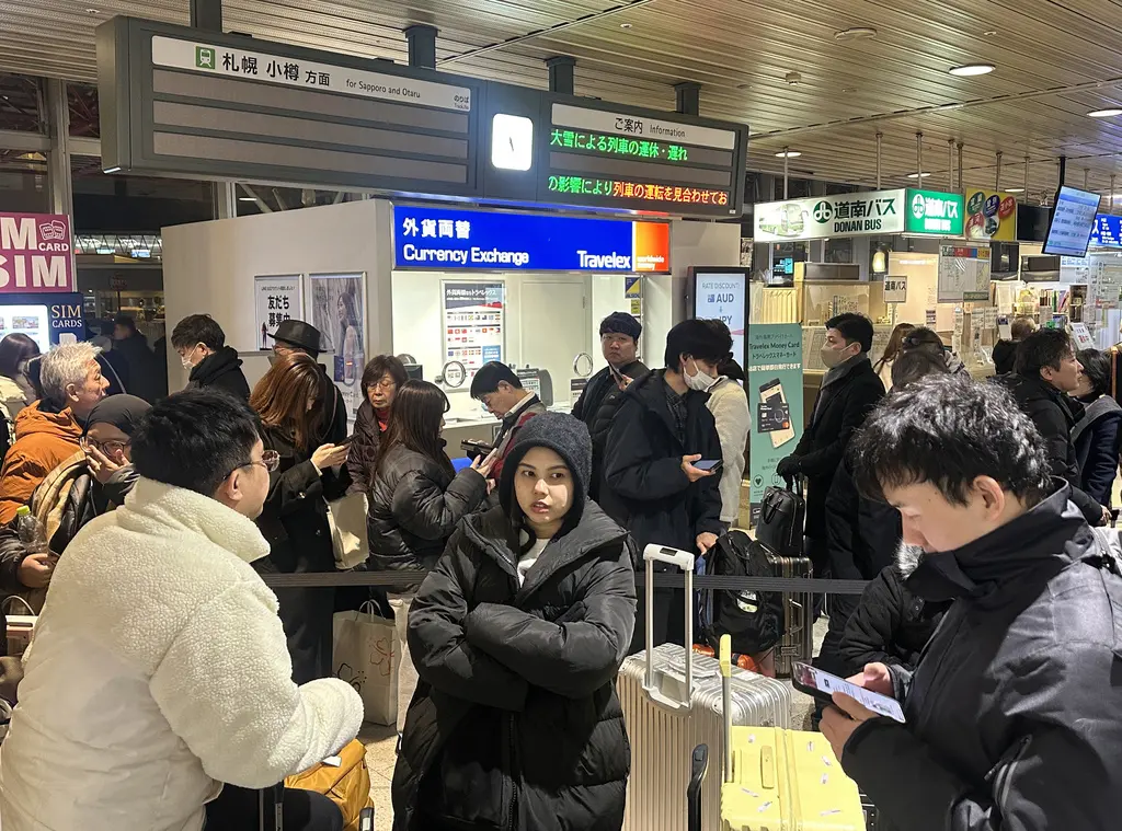 ▲北海道25日下起大雪，新千歲機場連外的JR列車、巴士全數停駛，約7000名旅客被困在航廈過夜。（圖／美聯社／達志影像）