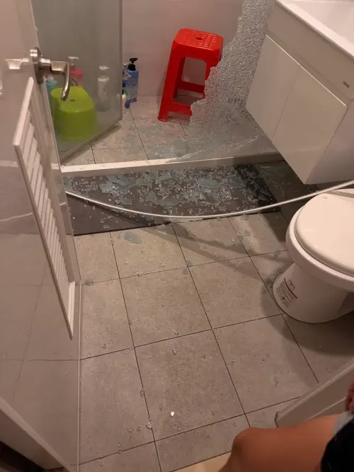 ▲玻璃門碎片散落一地，有網友提醒附近的牙刷等物品最好丟棄，以免玻璃碎片夾雜其中。（圖／Threads網友_ch.1ng授權提供）