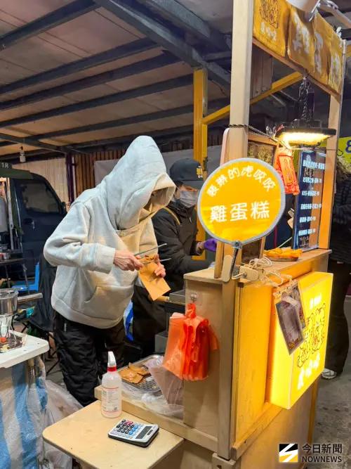 ▲裴琳（左灰帽T）今天在低溫寒風細雨中擺攤，親力親為製作雞蛋糕顧客。（圖／記者張一笙攝）