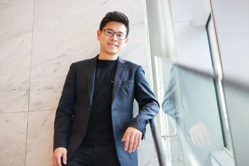 Jeff Hu stands in his office and smiles to the press before conducting an interview. (TCN)