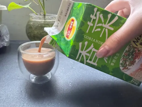 ▲全家香菜奶茶打開就可以聞到濃濃的香菜口味，聞不到明顯的花生味道，顏色是一般奶茶的褐色。（圖／記者鍾怡婷攝）