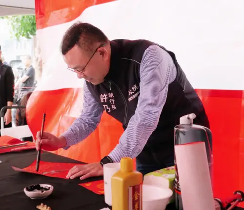 ▲ 執行長許乃文親自開筆題寫「春」、「福」二字，祈願社會繁榮與幸福。（圖／行政院南服中心）