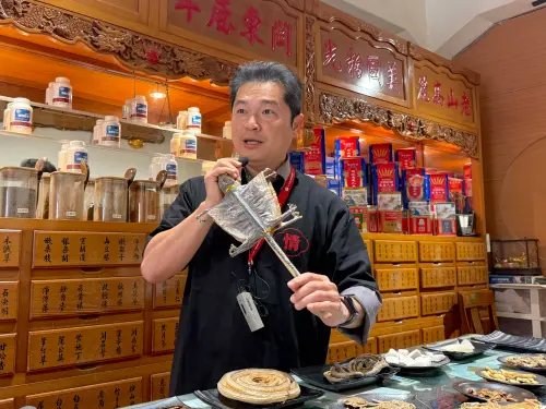 ▲「泰成藥行」老闆展示大守宮也是種中藥材。（圖／記者蕭涵云攝）