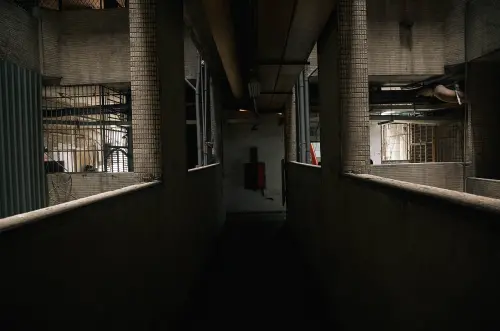 ▲西寧國宅內部走廊狹長且燈光昏暗，許多角落堆滿雜物，連前往會勘的市府官員都坦言「確實感覺不太舒服」。（圖／記者葉政勳攝）