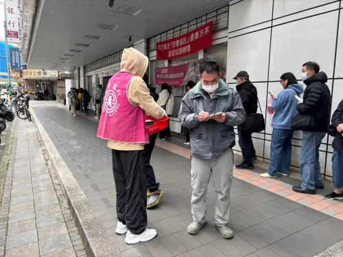 ▲部分銀行會在分行外安排工作人員，提供民眾換新鈔前能夠填寫張數的表單來縮短作業時間。（圖／記者張志浩攝）