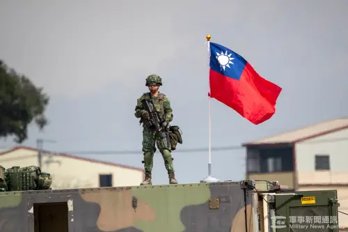 A serviceman stands next to the national flag amid intensified Lunar New Year readiness training. (MNA)