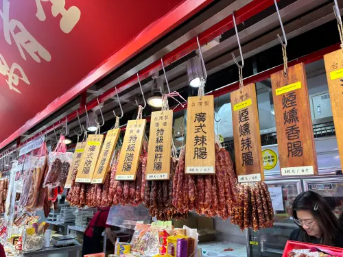 ▲老字號「萬有全」攤位前掛滿紅通通的廣式臘腸與湖南臘肉，濃郁的臘味香氣撲鼻而來，是南門市場最有年味的風景之一。（圖／記者徐銘穗攝）