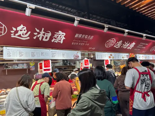 ▲主打「網購賣場名店」的逸湘齋，攤位前擠滿挑選佛跳牆與各類熟食年菜的民眾，是許多不想下廚家庭的首選。（圖／記者徐銘穗攝）