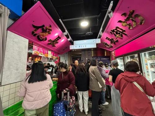 ▲曾獲「天下第一攤」金賞肯定的億長御坊，粉紅色的招牌下擠滿採買熟食的民眾，招牌心太軟、冰糖醬鴨都是必搶年菜。（圖／記者徐銘穗攝）