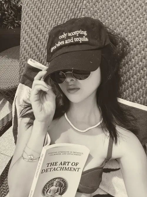 ▲廖思惟著三點式泳衣，躺在沙灘椅上看小說。（圖／廖思惟IG＠trinityliao）