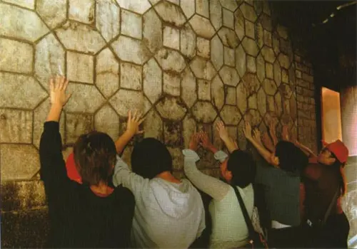 ▲信眾可特別參拜五王殿後方、青山寺前的金錢壁，其是咾咕石砌成的牆壁，金錢作九五排列，枚枚相疊，塊塊相扣。（圖／南鯤鯓代天府官網）