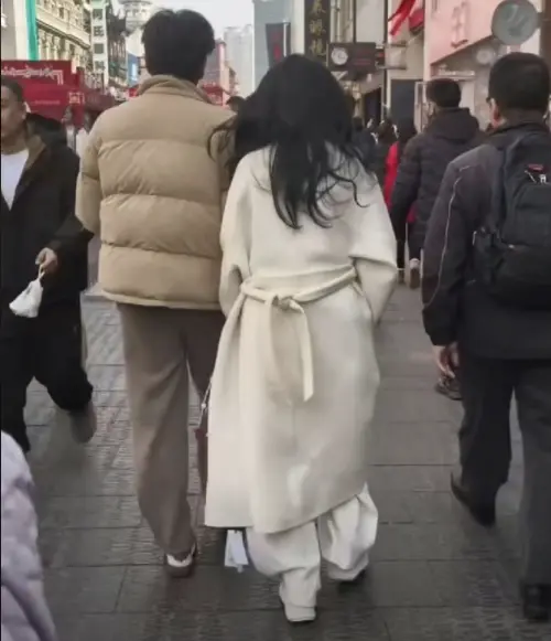 ▲伊能靜（右）身上的白色大衣，忘記剪吊牌，她一面往前走，吊牌就在大衣的左下方晃來晃去。（圖／摘自微博）