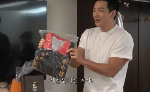 ▲Rain開箱台灣粉絲送的禮物，還拿出一件訂製款宮廟背心試穿。（圖／시즌비시즌 Season B Season YouTube）