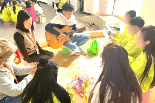 ▲台灣外籍收容人關顧協會人員彈吉他和受收容人歡唱，喜迎新年。(圖／移民署高雄收容所提供)