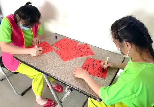 ▲收容所人員引導受收容人體驗手繪創作春聯，受收容人開心製作春聯。(圖／移民署高雄收容所提供)