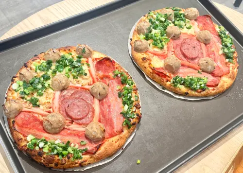 ▲滿貫砲披薩（售價299元），10吋大小不超過300元的高CP值價格，上方餡料超澎湃，讓歡呼聲與牽絲起司同步延伸。（圖／記者鍾怡婷攝）