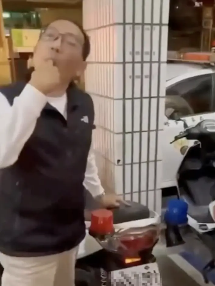 ▲徐姓所長在舔手指後,在車牌及車身摩擦,再將手指放入口中「驗車」。(圖/翻攝畫面)