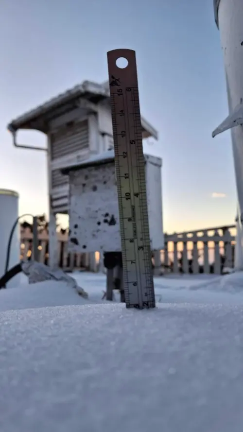 ▲ 歷經前兩日的降雪，氣象站人員今晨將直尺插入雪地中，紀錄下珍貴的畫面。氣象署補充指出，玉山氣象站早上仍有積雪約 5 公分，測量儀器與周邊木欄杆上也結滿了厚厚的冰霜。（圖／中央氣象署提供）