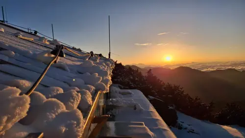 ▲清晨的曙光穿透雲層，金黃色的陽光灑落在被白雪覆蓋的氣象站屋頂與儀器上。放眼望去，一望無際的壯闊雲海將群山環繞，宛如置身國外仙境。（圖／中央氣象署提供）