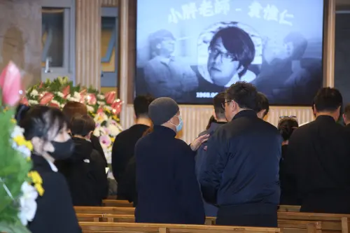 ▲袁惟仁告別式現場佈置莊嚴肅穆，大螢幕與會場中央的遺照，特別選用了袁惟仁生前戴著標誌性黑框眼鏡、專注彈奏吉他的身影。（圖／記者邱曾其攝影）