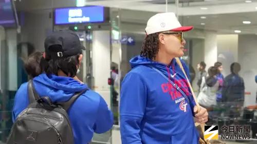 ▲陳傑憲（左）抱著已經熟睡的孩子，與張育成（右）一同等老婆下飛機。（圖／記者張一笙攝）