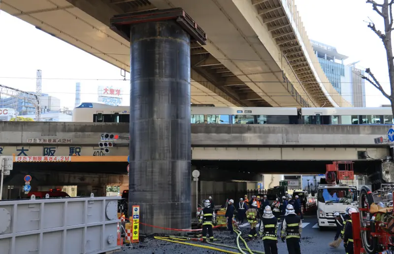    ▲日本大阪梅田中心地區，今（11）日一根埋在地下、長約30公尺直徑5公尺的鋼製管線，竟突然從地面竄出，隆起在地面外的高度約達18公尺，讓周圍用路人議論紛紛。（圖／美聯社／達志影像）  