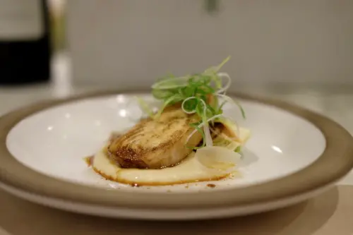 ▲以台灣土魠魚製作，底下洋蔥醬香甜潤口。（圖／記者葉盛耀攝）