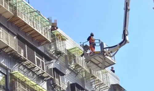 ▲新北板橋商圈14日下午驚傳女子坐在大樓遮雨棚疑似尋短，警消到場封閉道路並鋪設氣墊、升起雲梯車勸說，最終順利將女子救下送醫。（圖／翻攝畫面）