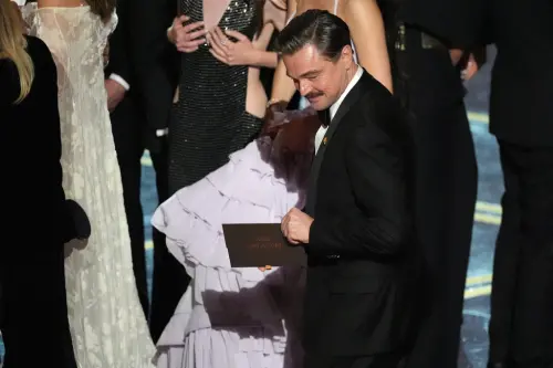 ▲李奧納多狄卡皮歐（中）手上拿著註明《一戰再戰》獲奧斯卡最佳影片的信封，露出笑容。（圖／美聯社／達志影像）