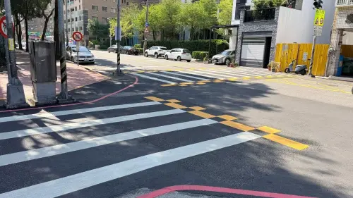 ▲中市府以上安國小為示範據點，將斑馬線寬度擴大至5至6公尺，再加上醒目的黃色棋盤格彩色行穿線，讓行人通行空間更充裕，也避免壅擠外溢情形。（圖／中市府提供www.taichung.gov.tw）