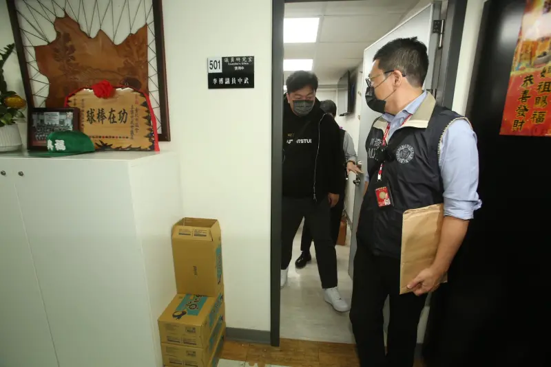    ▲搜索台北市議會的行動在下午3點結束，調查官將李傅中武（戴灰色口罩男子）帶回台北市調處訊問。（圖／記者邱曾其攝）  