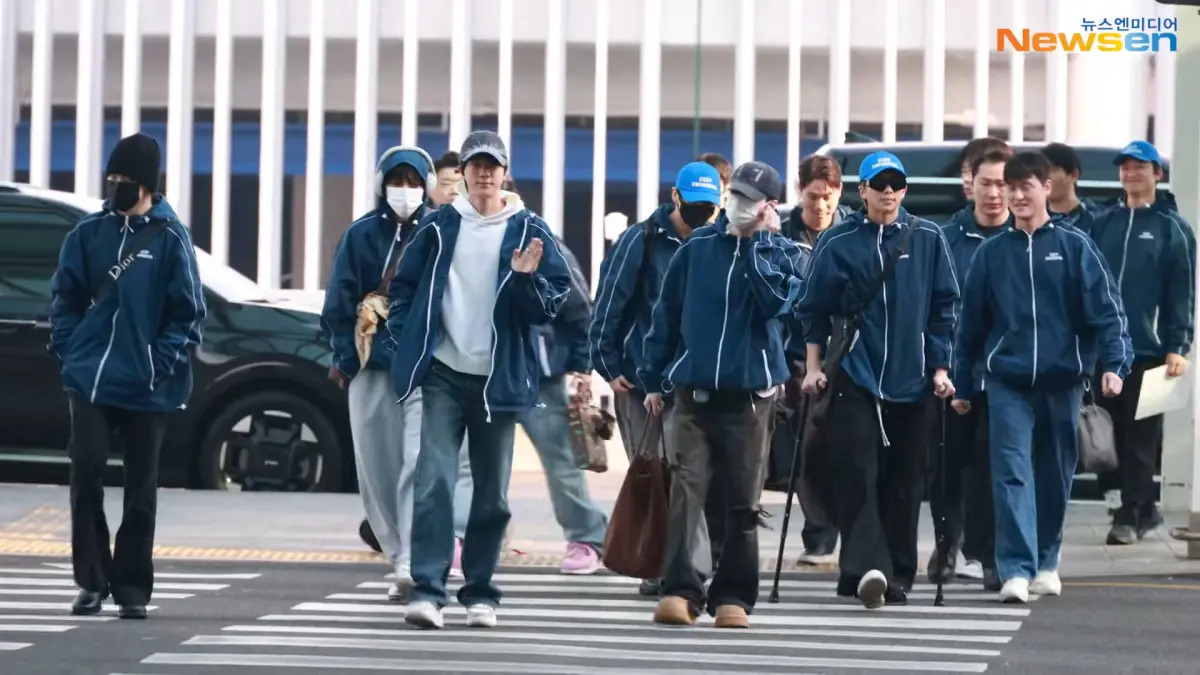 ▲BTS跟工作人員、保鑣穿一樣的衣服出境，上面通通印上「KEEP SWIMMING」，藉此宣傳《ARIRANG》新歌〈SWIM〉。（圖／YouTube@뉴스엔·Newsen）